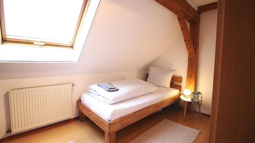 a small bed in a room with a window at Ferienwohnung am Wasserschloss 1-3 in Ochsenfurt