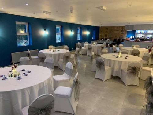 une salle à manger avec des tables et des chaises blanches dans l'établissement Crown at Worthington Hotel, à Standish