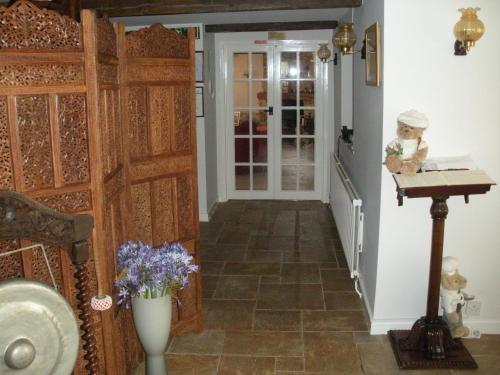 a hallway with a door and flowers in a room at Manor Farm Oast in Winchelsea