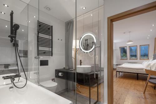 a bathroom with a shower and a sink and a mirror at Pytloun Wellness Hotel Harrachov in Harrachov