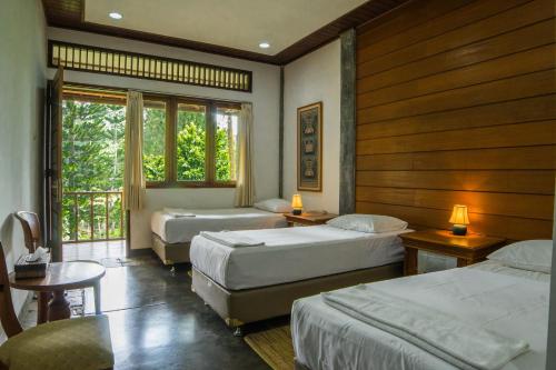 a hotel room with two beds and a window at Griya Dunamis by SABDA in Puncak