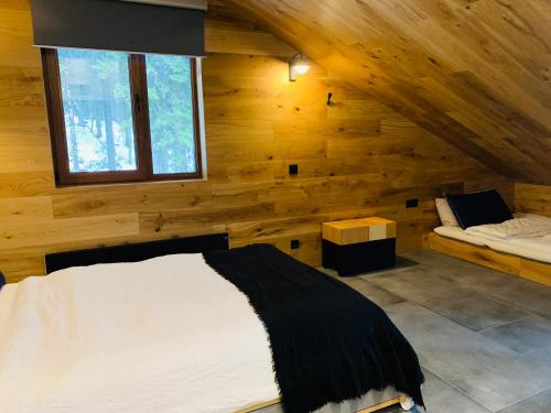 - une chambre avec un lit et une fenêtre dans une cabane en rondins dans l'établissement Golden Box Pamporovo, à Pamporovo