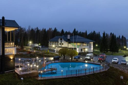 a large swimming pool in front of a house at Aateli Lakeside Chalets - former Vuokatti Suites in Vuokatti