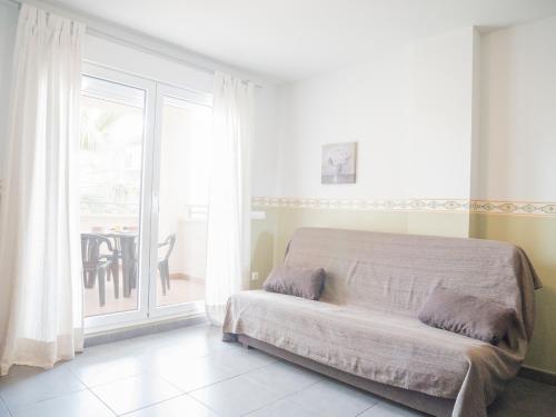 a bedroom with a bed and a balcony with a table at Marineu Las Arenas in Alcossebre