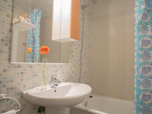 a bathroom with a sink and a vase with a flower at Marineu Las Arenas in Alcossebre