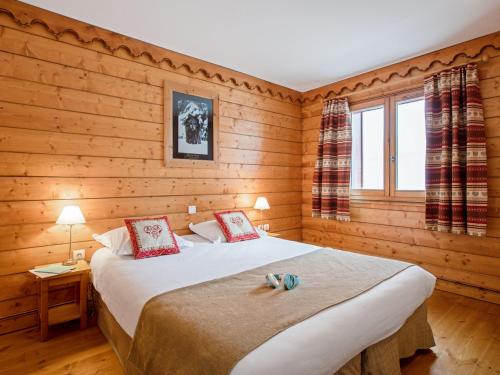 une chambre avec deux lits dans une cabane en rondins dans l'établissement Residence l'Ecrin des Neiges - maeva Home, à Tignes