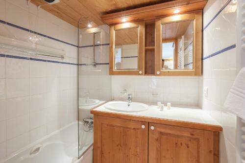une salle de bain avec un lavabo, des toilettes et une baignoire dans l'établissement Residence l'Ecrin des Neiges - maeva Home, à Tignes