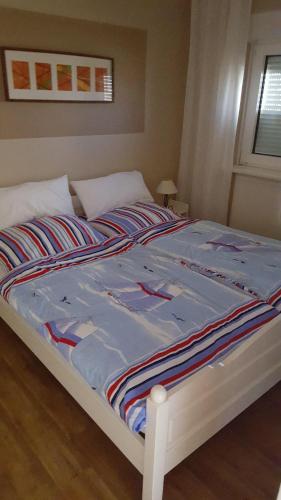 Una cama con una manta de colores encima. en Karl-Theo-Am-Wald, en Westerland