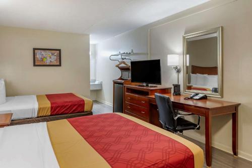 a hotel room with two beds and a desk with a computer at Econo Lodge North Charlottesville in Charlottesville