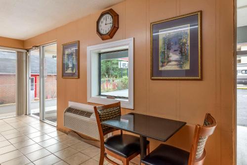 a dining room with a table and a clock on the wall at Econo Lodge North Charlottesville in Charlottesville