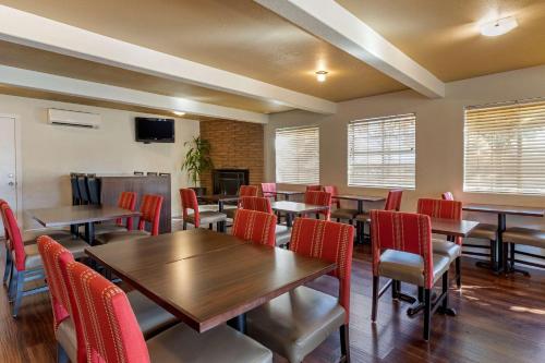 een restaurant met houten tafels en rode stoelen bij Comfort Inn Bishop in Bishop