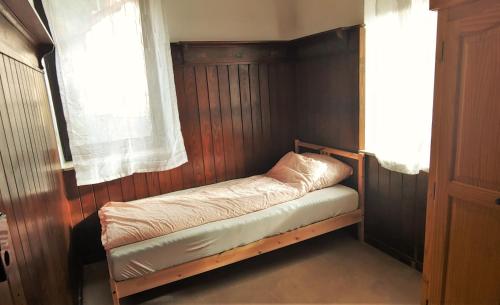 uma pequena cama num quarto com uma janela em Große Wohnung im Odenwald 1 em Schönau