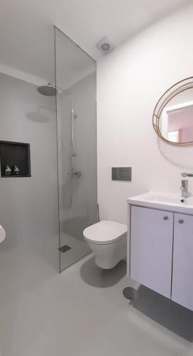 a white bathroom with a toilet and a sink at Casa Vinte & Cinco Alojamento Local in Penha Garcia