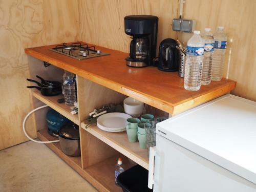 een plank in een keuken met een koffiezetapparaat en een koffiepot bij Les Refuges de Mer 