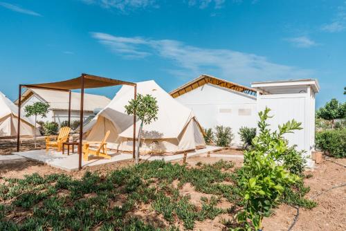 a group of tents in front of a white building at Sails on Kos Ecolux Tented Village in Marmari