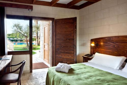 sypialnia z łóżkiem i przesuwnymi szklanymi drzwiami w obiekcie UNAHOTELS Regina Bari w mieście Torre a Mare