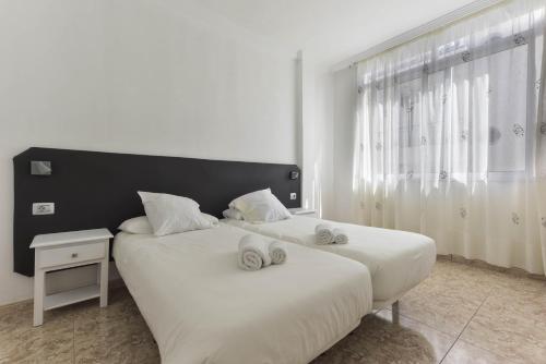 a bedroom with two beds with towels on them at Apartamento Bregador in Playa de San Juan