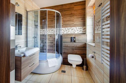 a bathroom with a shower and a toilet and a sink at Apartamenty Majerczyk in Zakopane