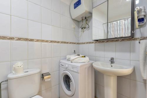biała łazienka z pralką i umywalką w obiekcie Apartamento Albatros w mieście Playa de San Juan