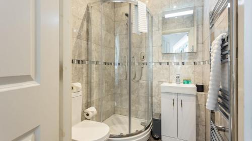 een badkamer met een douche, een toilet en een wastafel bij Daintree - Bournemouth in Bournemouth