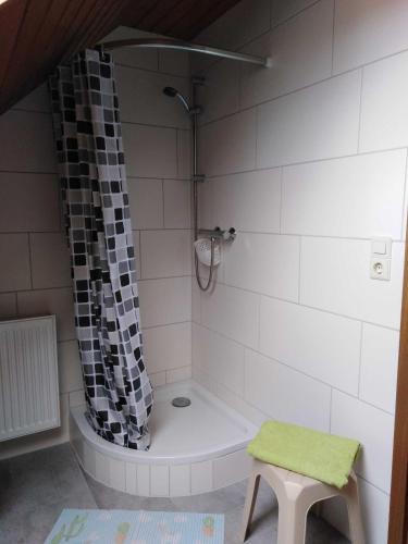 a bathroom with a tub and a shower with a stool at Ferienwohnung Fehncharme 85100 in Ostrhauderfehn