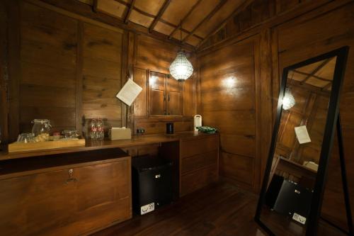 a kitchen with wood paneling and a counter and a mirror at Rumah Jembarati in Cangkringan
