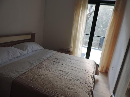 a bedroom with a bed and a large window at Apartments Lori in Biograd na Moru