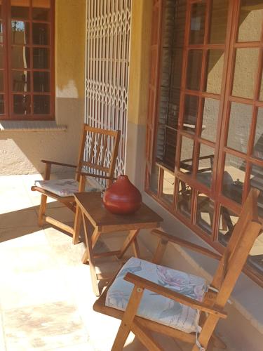 two chairs and a vase sitting on a porch at The Leopard Tree in Polokwane