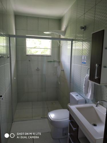 uma casa de banho com um chuveiro, um WC e um lavatório. em Flat Agradável Pomerode em Pomerode