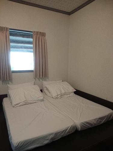 a bed with two pillows and a window in a room at Jinguang Homestay in Fanlu