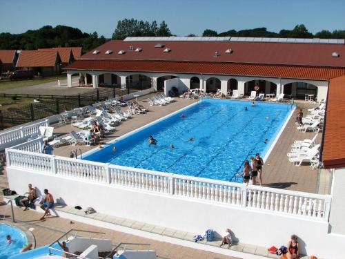 a large swimming pool with people sitting around it at Feriepark Langeland Emmerbølle (Feriepark Langeland) in Emmerbølle