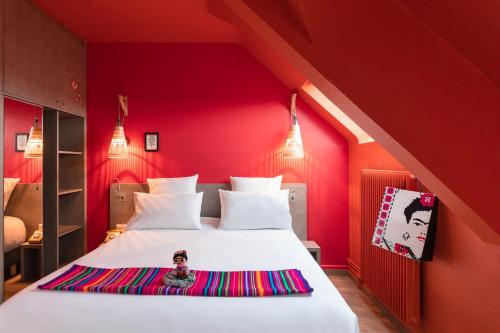a bedroom with a large white bed with red walls at PAUL & PIA - Welcome Home Hotel in Colmar