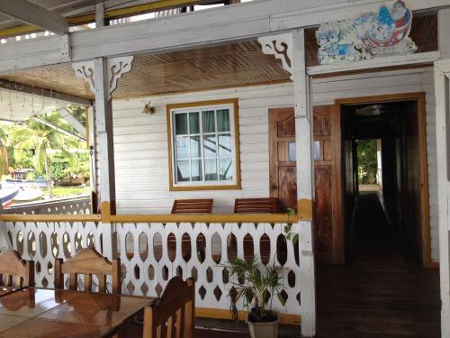 a porch of a house with a table and chairs at Hotel Caribbean View in Bastimentos