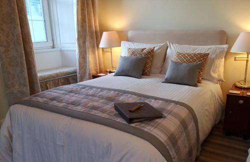 Un dormitorio con una cama grande y una bandeja. en Lossiemouth House en Lossiemouth