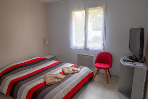 - une chambre avec un lit, une chaise rouge et une télévision dans l'établissement Maison individuelle avec jardin proche Poitiers, à Roches-Prémarie-Andillé