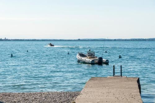 a small boat in the water near a dock at Camping Fontanelle in Moniga