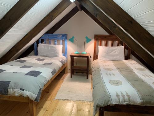 a attic bedroom with two beds and a table at Mad About Saffron in Stormsrivier