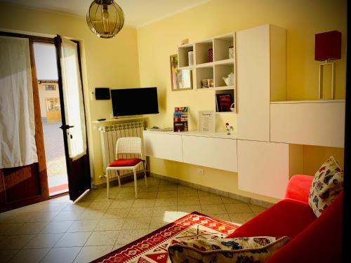 a living room with a red couch and a tv at Agriturismo Cascina Mariale in Albiano dʼIvrea