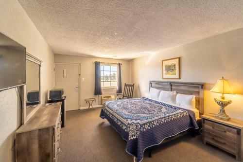 a hotel room with a bed and a flat screen tv at Dothan National Golf Club and Hotel in Dothan