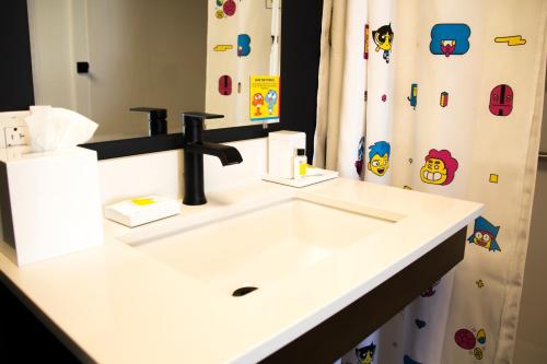 a bathroom with a white sink and a shower curtain at Cartoon Network Hotel in Lancaster