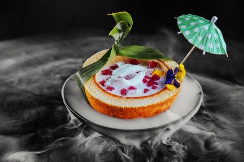 a piece of cake on a plate with an umbrella at Dusit Thani Dubai in Dubai