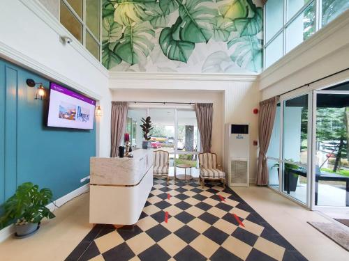 sala de estar con suelo a cuadros y paredes azules en Fortune Courtyard Khao Yai Hotel Official en Mu Si