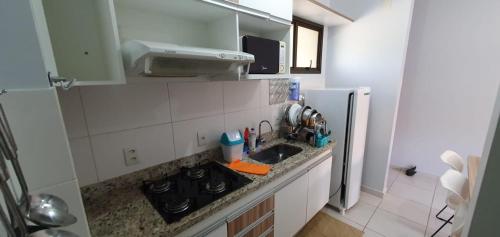 a small kitchen with a sink and a refrigerator at Lindo Apartamento no Aldeia do Lago em Caldas Novas in Caldas Novas
