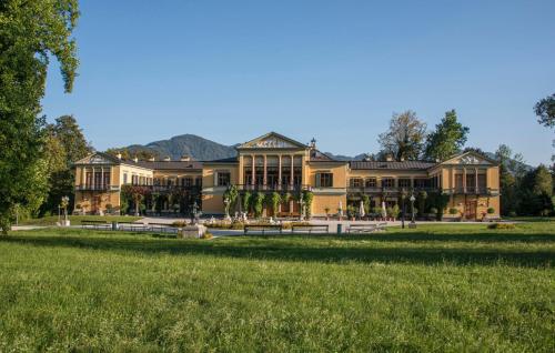 a large building with a grass field in front of it at Apartment Stella in Bad Ischl