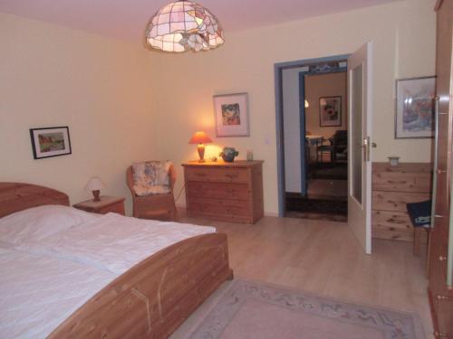 ダゲビュルにあるHaus-Halligblick-Ferienwohnung-Olandのベッドルーム1室(ベッド1台付)、椅子付きのベッドルーム1室が備わります。