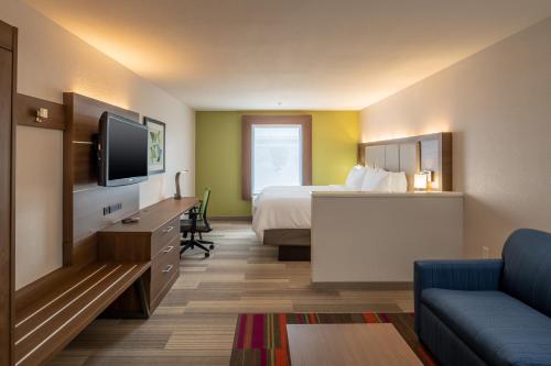 Cette chambre comprend un lit et une télévision à écran plat. dans l'établissement Holiday Inn Express & Suites N Waco Area - West, an IHG Hotel, à West