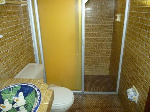 a bathroom with a toilet and a glass shower at Hotel Posada Los Arcos in Oaxaca City