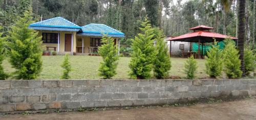 a house with a blue roof and a red umbrella at Villa Vibes in Chikmagalūr