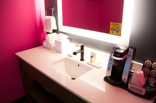 a bathroom with a white sink and a mirror at Cartoon Network Hotel in Lancaster
