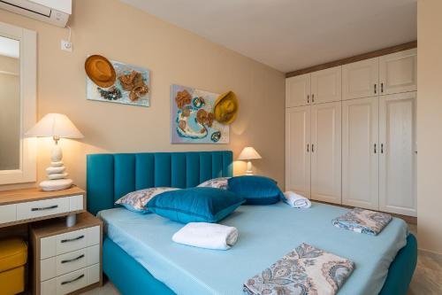 a blue bed with blue pillows in a bedroom at Aquamarine in Pomorie